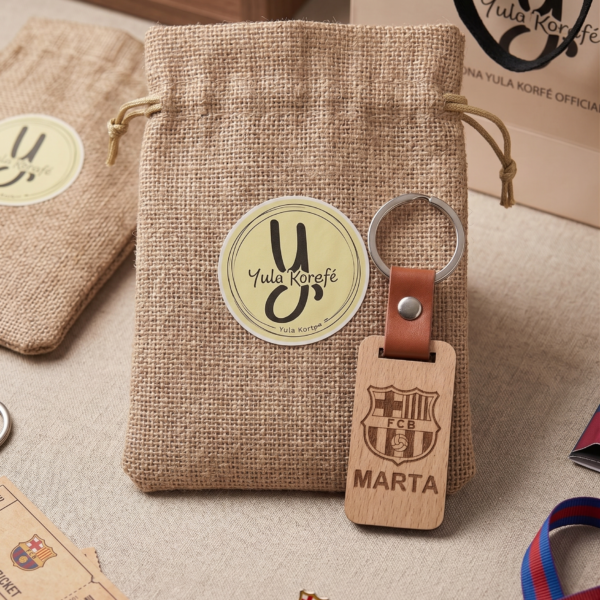 Llavero de madera personalizado de Yolascraft con el escudo del FC Barcelona y el nombre Marta grabado, junto a su bolsa de rafia artesanal.