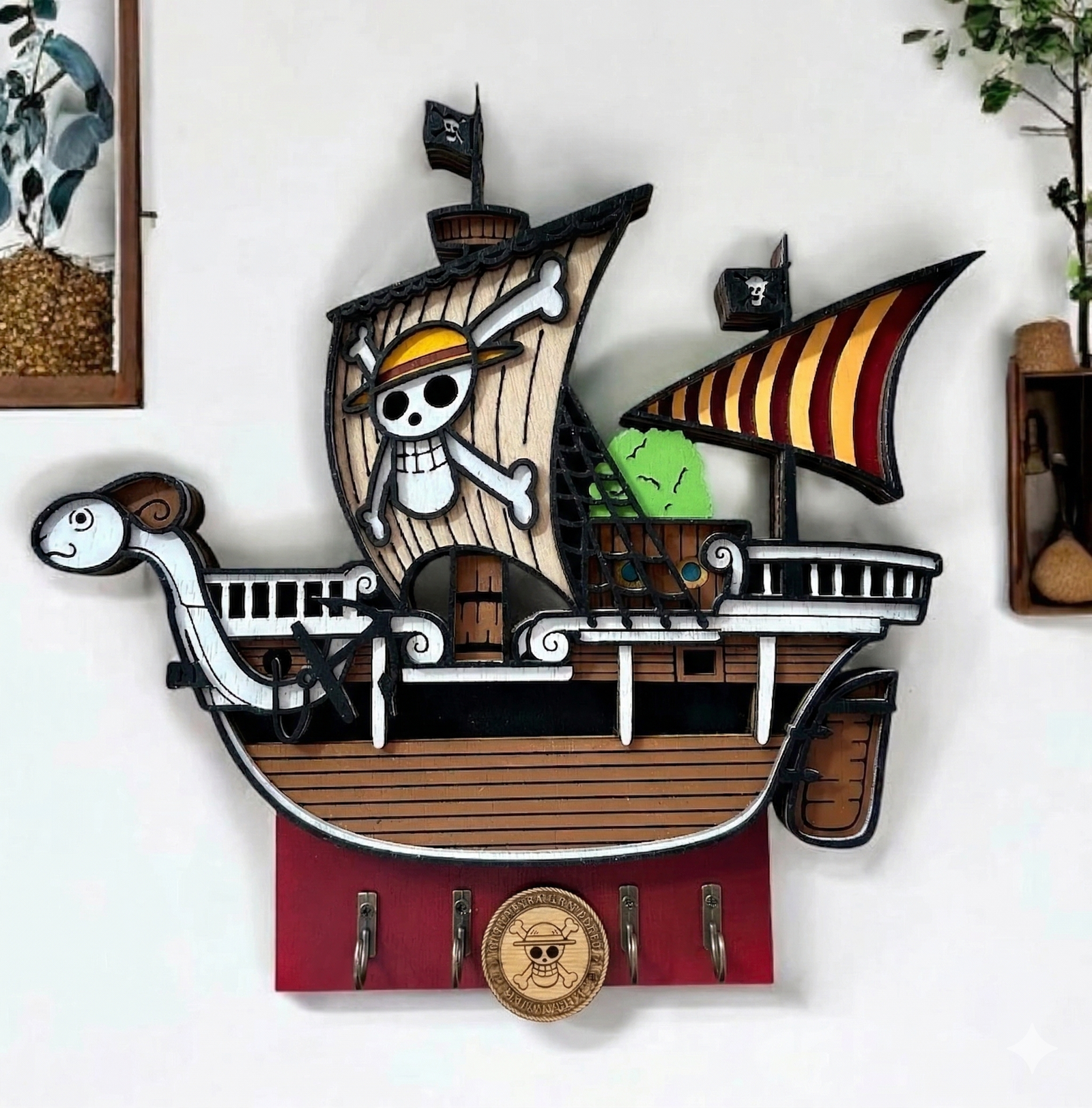 Colgador de llaves artesanal de madera 3D del barco One Piece Going Merry, mostrando el modelo detallado en capas y los cuatro ganchos metálicos para llaves.