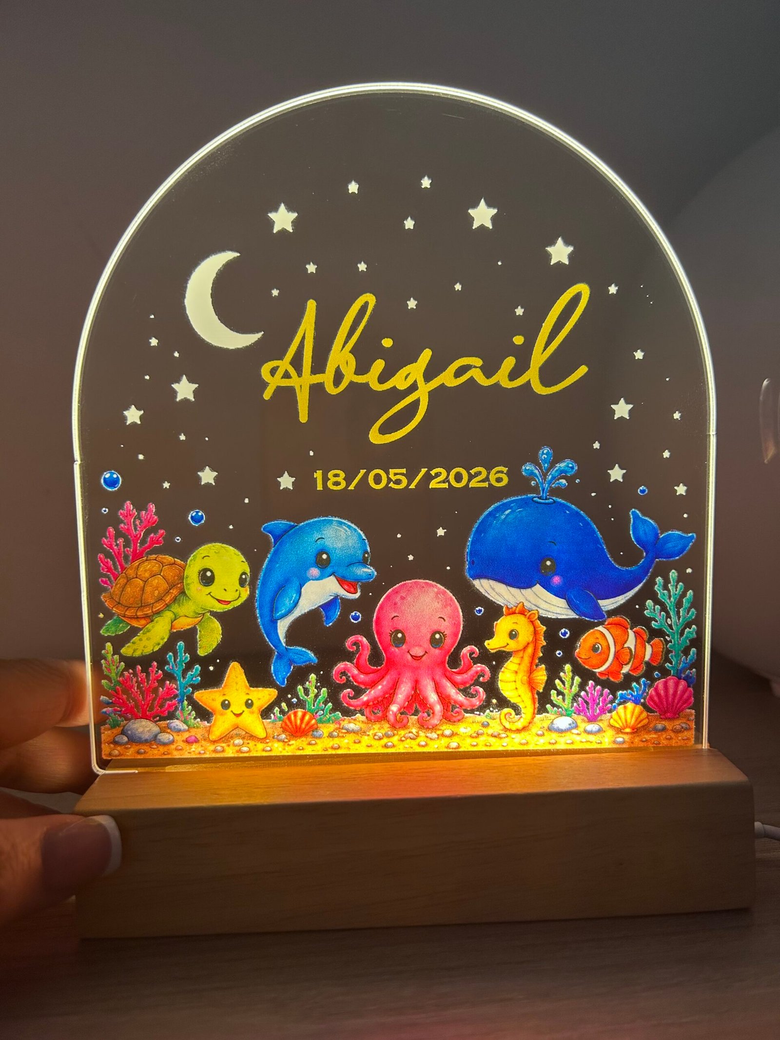 Lámpara de noche LED para bebé personalizada de Yolascraft modelo Mar encendida con el nombre Abigail y fecha de nacimiento, con dibujos del fondo del mar.