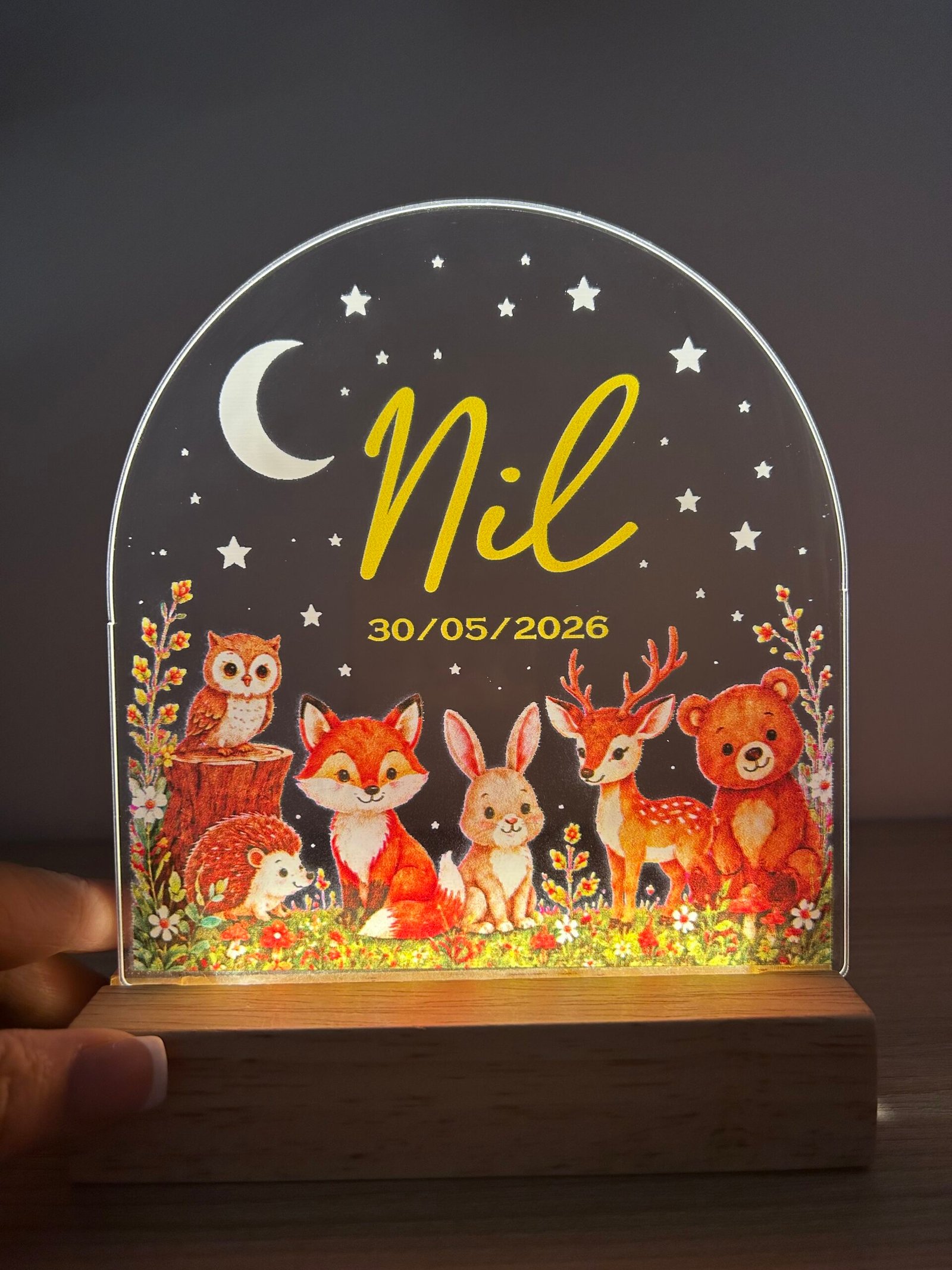 Lámpara LED infantil personalizada de Yolascraft modelo Bosque iluminada con el nombre Nil y fecha de nacimiento, sobre base de madera.